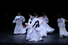 Dancers in white costumes dancing on stage